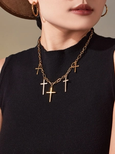 Détail du collier plaqué or 18 carats avec cinq pendentifs croix et boucles d'oreilles
