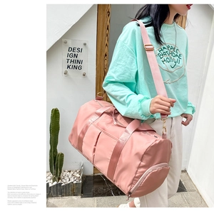 Detail view of pink travel bag with separate shoe compartment and adjustable shoulder strap