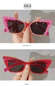 Detail view of pink cat eye sunglasses featuring sparkling rhinestone chain accents