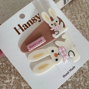 Close-up of cute felt bunny hair clip and brown clip with Good Luck embroidery