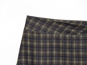 Detail van de donkergroene en blauwe ruitjesstof textuur en tailleband stiksels