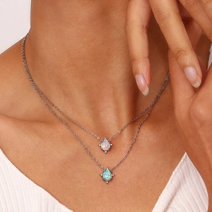 Detail closeup view of double layer stainless steel necklace with teardrop opal pendants.