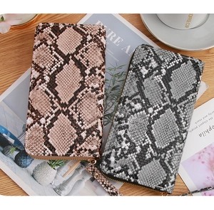Close-up of snakeskin pattern texture and zip closure on high-capacity long clutch wallet
