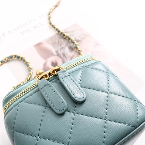 Detail of teal quilted lambskin texture and gold chain on mini cosmetic shoulder bag