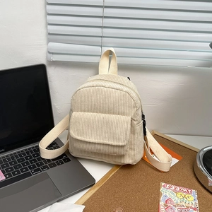 Minimalist beige corduroy mini backpack on office desk with laptop and decor