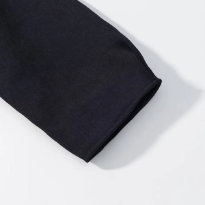 Close-up of high-quality black twill fabric detailing the sleeve cuff and precise stitching