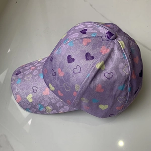 Close-up of shiny purple kids baseball cap with colorful heart patterns and leopard texture