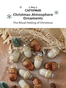 Detailed close-up of metallic acorn Christmas ornaments with glitter on festive snow base