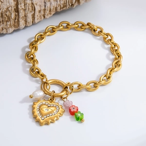 Detailed shot of golden link bracelet with evil eye heart pendant and small flowers