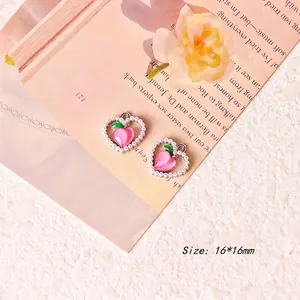 Detail shot of heart-shaped peach charm with pink enamel, faux pearls and 16x16mm dimensions