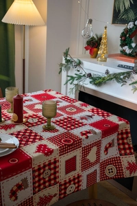 Detailed view of red plaid Christmas tablecloth with festive tree and heart patchwork patterns
