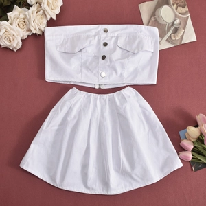 Flat lay of white two-piece set featuring buttoned tube top and pleated mini skirt on red