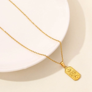Detailed macro view of an 18K gold-plated moon and eye pendant on a delicate cable chain