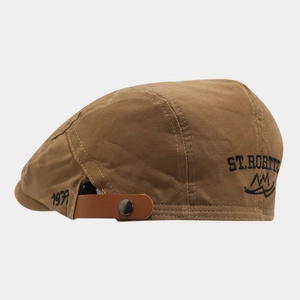 Detail of St. Moritz embroidery and adjustable leather strap on brown flat cap