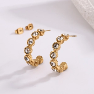 Detail of gold C-shaped earrings with micro-paved cubic zirconia and butterfly backings