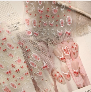 Detail of floral nail stickers with red dried roses and white lace bow designs