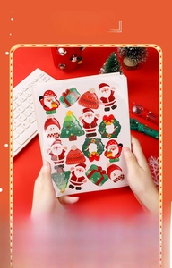 Detail of Christmas stickers set featuring Santa, trees, and wreaths on a red festive desk