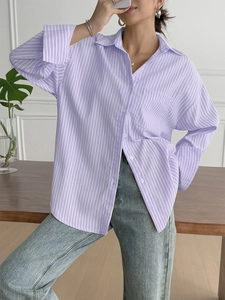 Detail of purple and white striped button-down shirt with chest pocket and cuffs