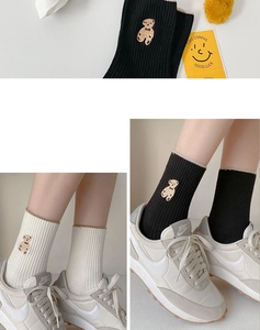 Détail de chaussettes mi-hautes côtelées avec broderie d'ours en noir et blanc