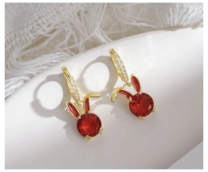 Detail of red rabbit earring charms with gold metal and sparkling white zircons