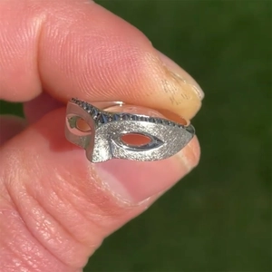 Vintage silver masquerade mask ring with black rhinestones shown in a natural setting