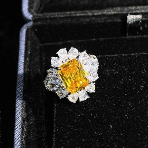 Macro detail of luxury square yellow gemstone ring with floral accents in black velvet box