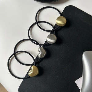 Close-up of four high-elastic hair ties with gold and silver metal heart and round charms
