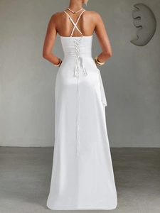 Detail of elegant white satin maxi dress featuring a cross-back strap and lace-up waist