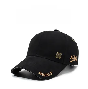 Detailed close-up of a black baseball cap featuring premium gold embroidery and metallic patch
