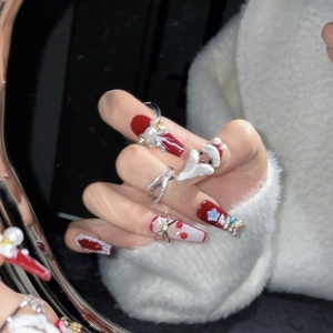 Handmade Christmas press-on nails in red and white coffin shape with 3D Santa and pearls