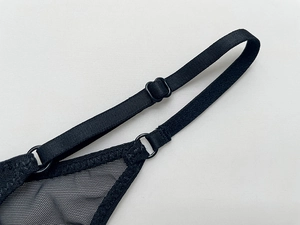 Detail of adjustable straps and mesh texture on black embroidered scorpion thong