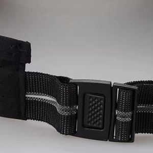 Close-up of adjustable black nylon strap with reflective strip and plastic buckle on cap