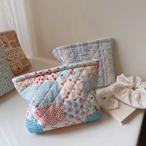 Macro shot of quilted cotton makeup bags with floral patterns and zipper detail