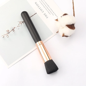 Flat top foundation brush with black matte handle and rose gold ferrule on white background