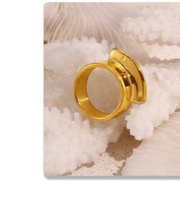 Macro detail of sculptural 18k gold plated stainless steel ring on coral texture