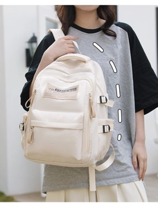 Detailed side view of beige canvas backpack showing large capacity and side buckle straps