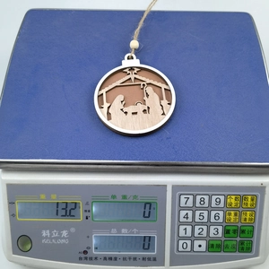 Detail of wooden nativity scene ornament on a digital scale showing weight of 13.2 grams
