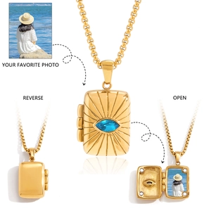 Locket necklace detail showing gold rectangular tarot pendant with blue stone and photo compartment
