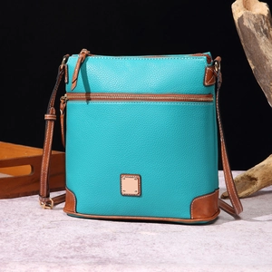 Detail of mint green crossbody bag featuring pebbled lychee texture and brown trim
