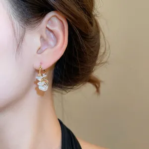 Elegant 18k gold-plated geometric hoop earrings with crystal clusters on model