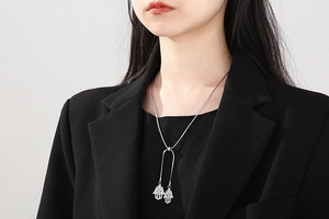 Détail de pendentifs main de Hamsa sur une chaîne serpent réglable portée par un mannequin