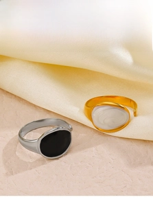 Detail of adjustable gold and silver rings with black and white oval marble inserts