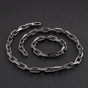 Detail view of black titanium chain necklace and bracelet set with hammered texture finish