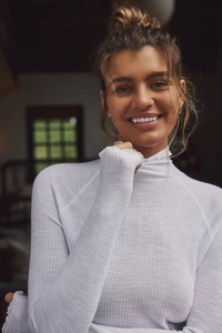 Detailed texture of white waffle knit high neck slim-fit shirt with delicate lettuce trim