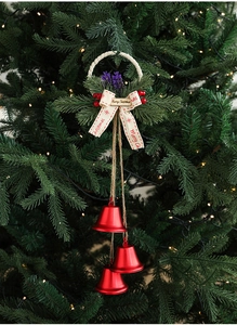 Close-up of red Christmas bells with pine needles and berries hanging on a tree
