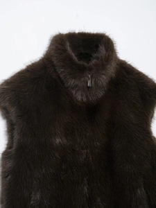 Dettaglio gilet in pelliccia sintetica marrone scuro con collo alto e zip metallica