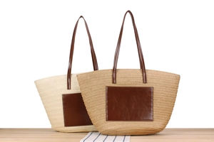 Detail of straw woven tote bags in beige and khaki with leather pockets and shoulder straps