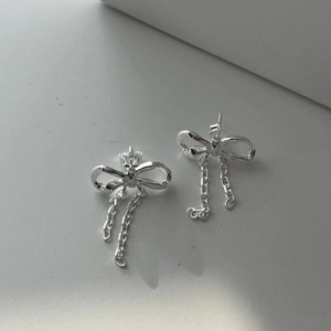 Detail view of S925 sterling silver bow earrings with elegant dangling chain tassels