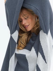 Macro detail of dark grey and white geometric jacquard knit texture on a crewneck sweater