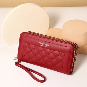 Detail of red quilted PU leather long wallet with double zippers and wrist strap
